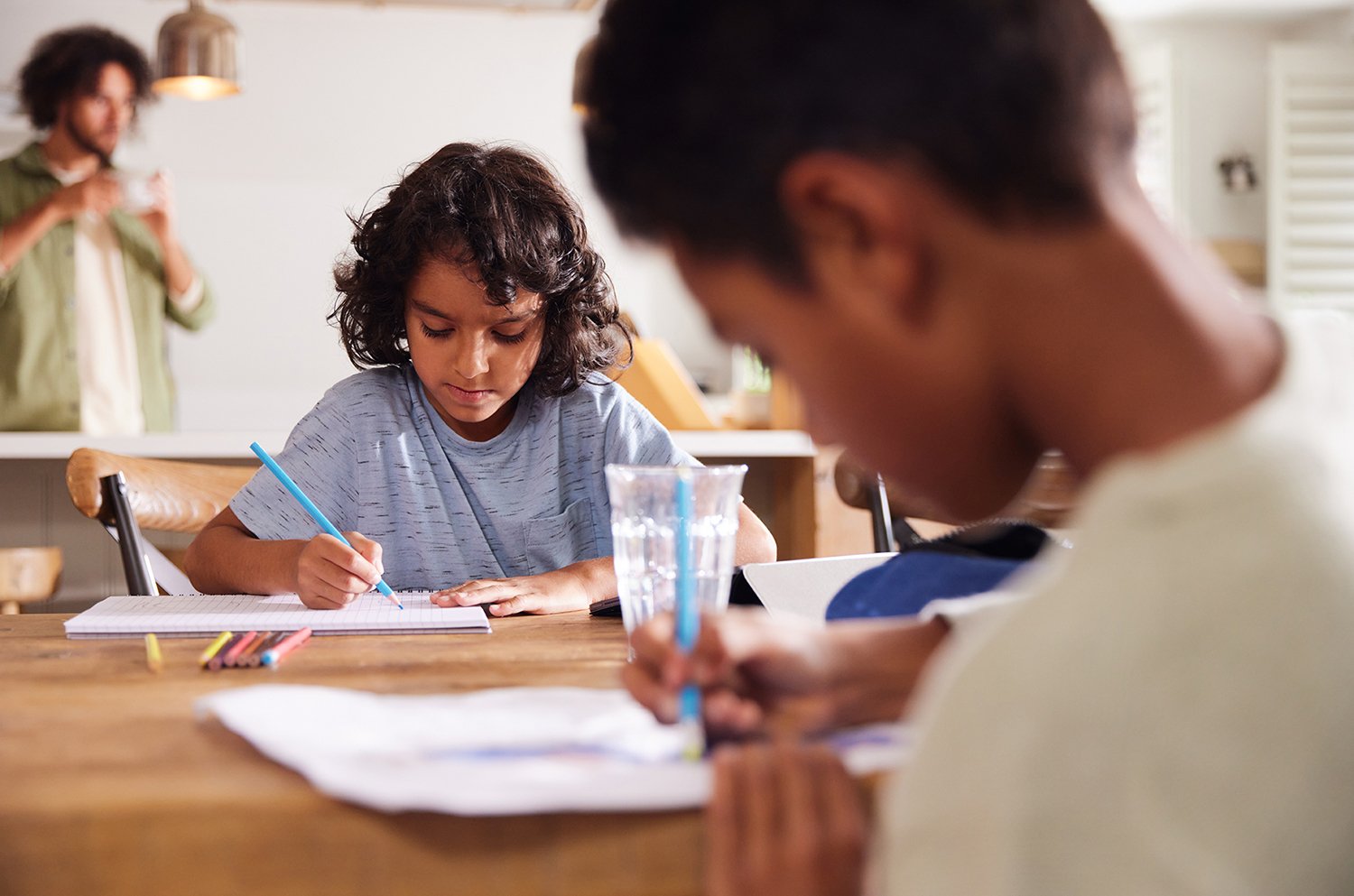 Two elementary school students sitting at a table and drawing