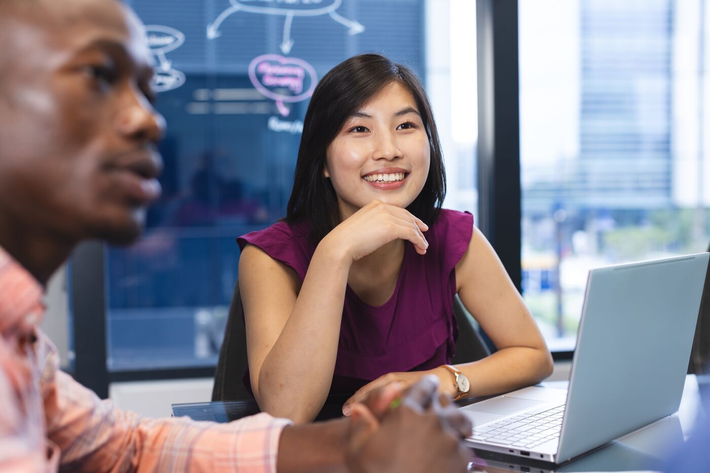 Two colleagues discussing insights together at a laptop
